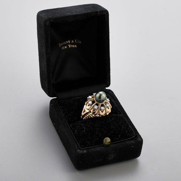 TIFFANY & CO. BLACK PEARL AND DIAMOND RING: Circular open bombe centers 8.4 mm. black pearl, eight prong set diamonds, approx. .56 ct. TW, ca. 1980; Marked 14k, Tiffany & Co.; Size 8; 10.1 dwt.; Original box