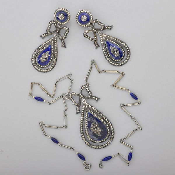 EDWARDIAN MARCASITE AND ENAMELED SILVER PARURE: Designed as ribbon bows suspending articulated royal blue enameled pendeloques, pendant 2 1/4", on fetter link chain with seed pearl and enameled stations, 18"; Ear clips with circular surmounts, 2 3/