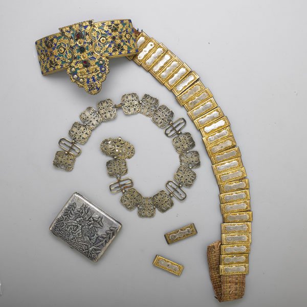 TWO ORNAMENTAL BELTS AND A RUSSIAN SILVER CARDCASE: Three pieces: Edwardian silver plated nurse's belt with linked panels in floral design; Gilt and enamel Hungarian bridal belt set with "gems," twenty eight ornamental sliding panels over cloth belt at