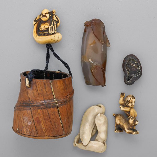 THREE ANTIQUE IVORY NETSUKES AND A SNUFF BOTTLE: Seated tradesman Netsuke supports carved burl bucket; Netsuke in the form of three bean pods; Netsuke in the form of playful boy and dog; Vegetal carved hardstone snuff bottle with base (as found); Ja
