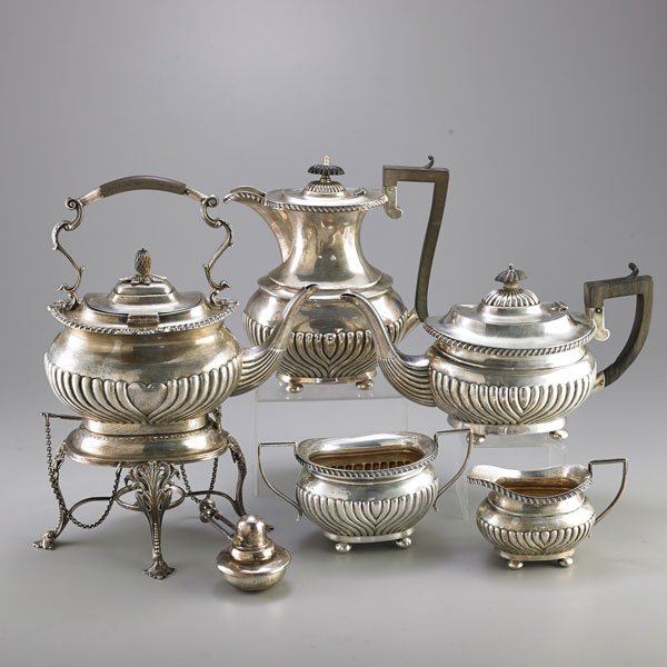 ENGLISH SILVER COFFEE SERVICE AND TEA SERVICE: Comprising sterling kettle on stand, teapot, coffee pot, sugar and creamer with half reeded lower body and ebonized wood handles, kettle with heart shaped reserve, stand with scrolling acanthus and le