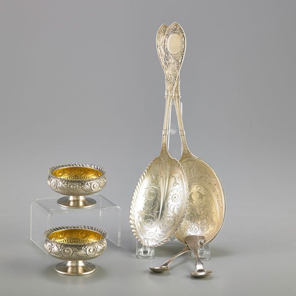 AMERICAN SILVER SERVING SPOONS AND SALT CELLARS: Six pieces: Two struck, embossed, bright cut sterling serving spoons in pattern "Arabesque", W. Wilson & Son, Philadelphia, 1857-1909, 9 3/8"; Pair of footed floral sterling salt cellars with gilt int