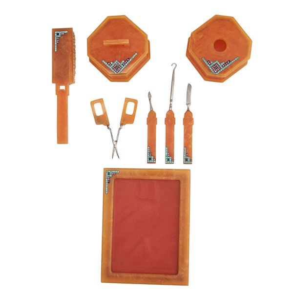 ART DECO CELLULOID SPARKLER BOUDOIR SET: Eight pieces: Orange celluloid picture frame, boar's hair brush, rouge and powder pots, button hook, scissors and two manicure accessories, each embellished with geometric rhinestone designs, ca. 1935