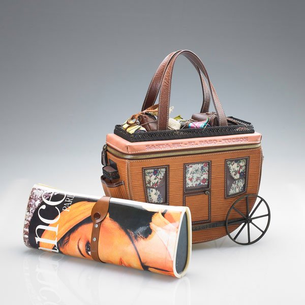 TWO NOVELTY HANDBAGS: Braccialini leather stagecoach handbag, with miniature luggage, on wheels 10 1/4" x 13 1/4" above handles; Magazine clutch handbag, 12" x 4 1/4"; Second half 20th c.