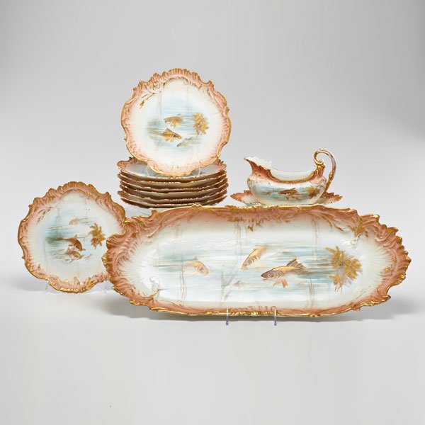 LIMOGES PORCELAIN: Transfer-decorated fish service: serving platter, saucier boat, and nine plates, France, ca. 1900; All marked; Platter: 2 1/2" x 24" x 9"