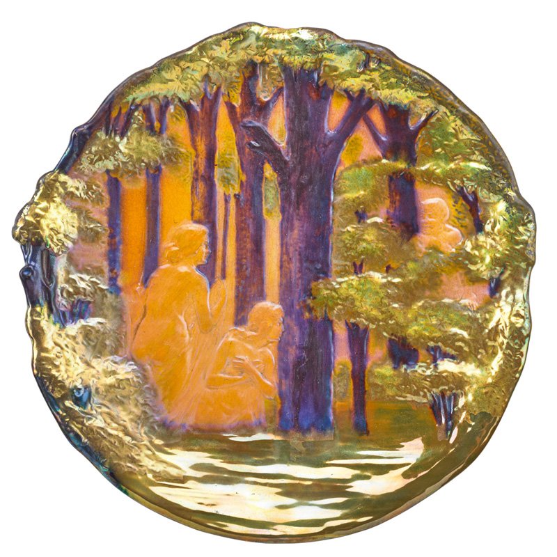 ZSOLNAY Plaque with nude maidens and satyr: LAJOS MACK (Attr.) ZSOLNAY Plaque with nude maidens and a satyr, eosin glaze, Pecs, Hungary, ca. 1900; Raised five churches seal, stamped 6873/36/0; 13" dia.