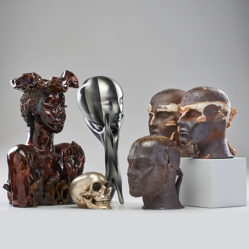 STYLE OF WAYLANDE GREGORY; ETC: Six pieces: ceramic bust, face with hands, metal skull, and three cast iron heads, mid 20th c.; Bust marked RR; Tallest:17 1/2" x 12" x 8"