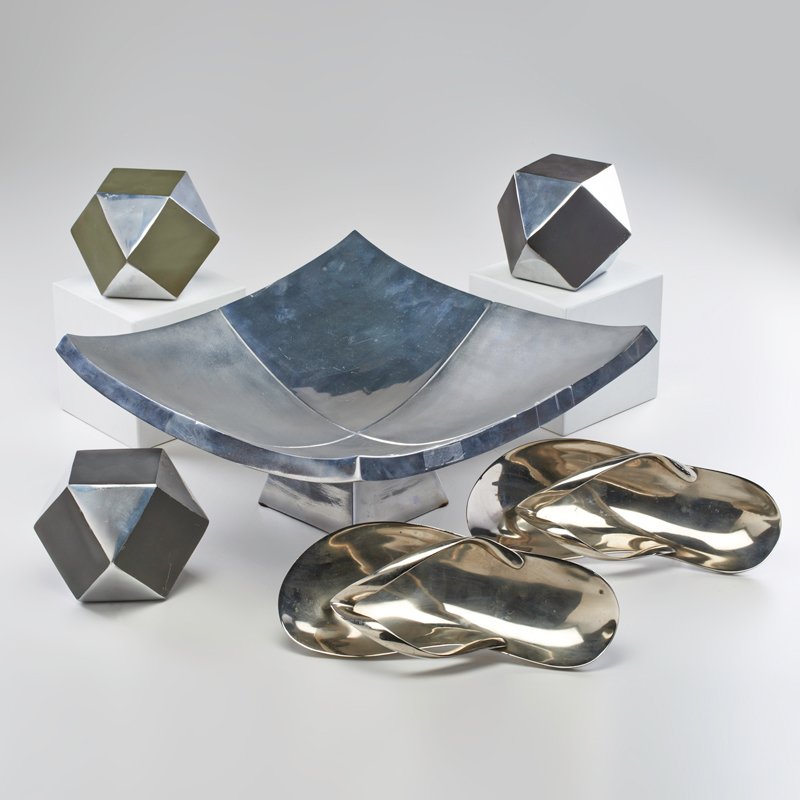 CONTEMPORARY: Centerpiece bowl and three geometric forms; Together with two decorative sandals; Chromed metal, leather; Unmarked; Bowl: 8" x 16" x 16"