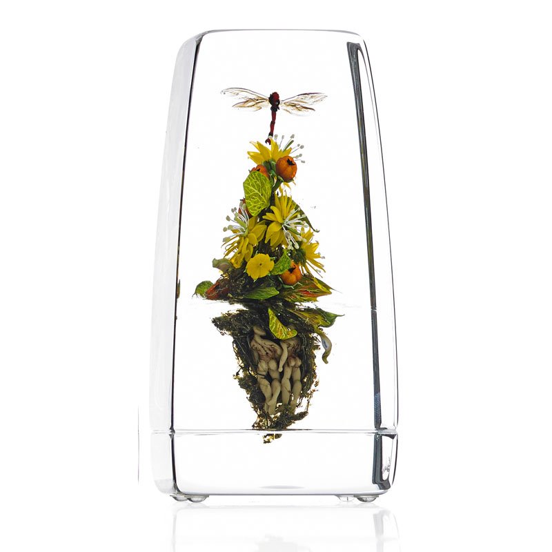 PAUL STANKARD Tall glass Botanical paperweight: PAUL STANKARD (b. 1943) Tall lampworked glass Botanical paperweight with flowers, berries, dragonfly, root people, mask, and word canes, Millville, NJ, 2003 Signed and dated 5 3/4" x 2 1/2" sq.