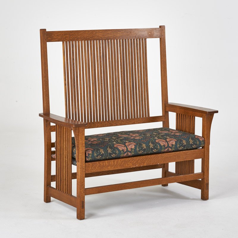 STICKLEY BY E.J. AUDI: Contemporary spindled settee in the style of Gustav Stickley, Manlius, NY, ca. 1990; Quartersawn oak, upholstery fabric in the style of William Morris; Metal tag, branded mark, upholstery label; 48 1/