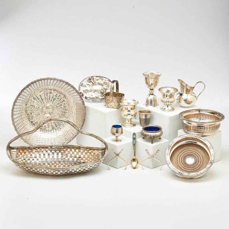 SILVER AND SILVER PLATE GROUPING: Sixteen pieces including: three silver-plate woven baskets, two silver-plate mounted wine coasters, sterling thimble, sterling creamer, etc. America and Europe, 19th/20th c.; Most marked; Largest bask