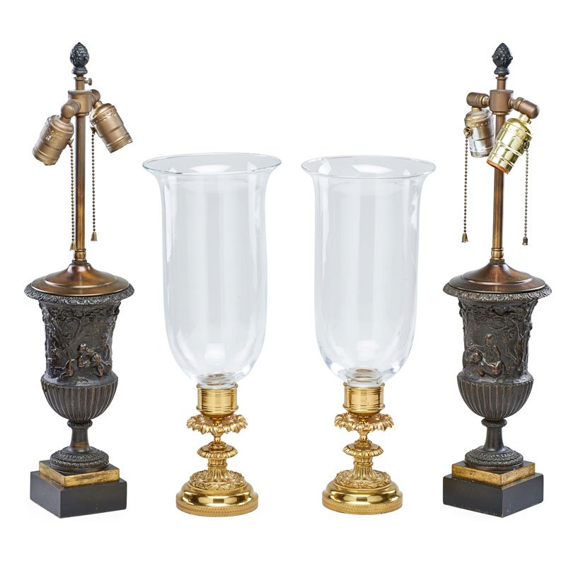 TRADITIONAL LIGHTING: Four: two hurricane lamps with foliate brass pedestal bases and two urn form lamps with classical decoration; Urn lamps: 23"