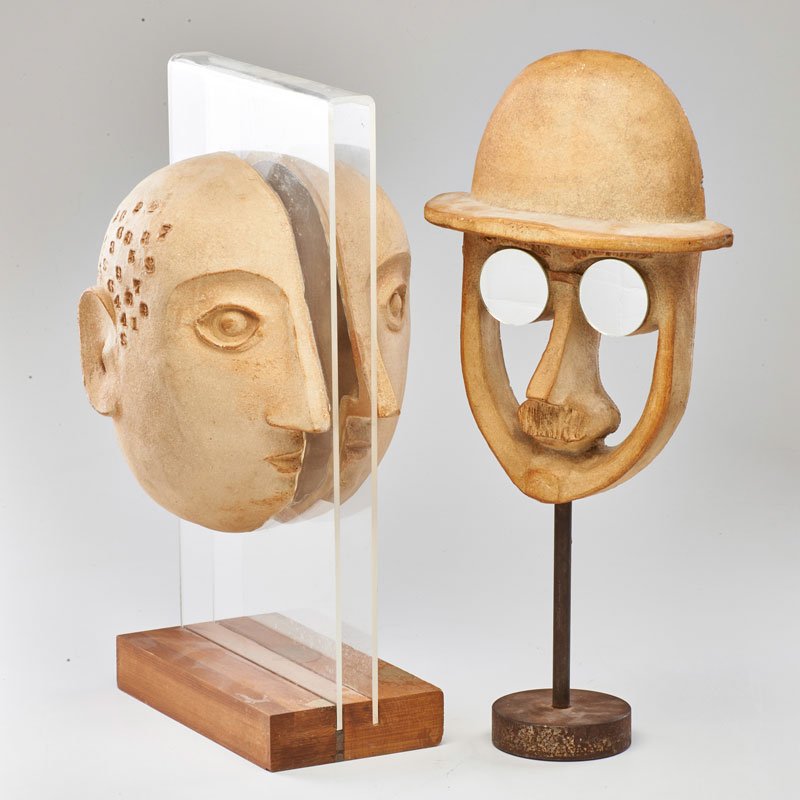 DAVID GIL; BENNINGTON POTTERS: Two face sculptures, Bennington, VT, ca. 1990; Stoneware, wood, acrylic, mirrored glass, iron; One with impressed Bennington mark; Taller: 20" x 9" x 4"