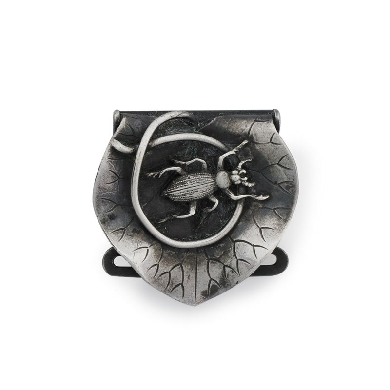 SCHIEBLER JAPANESQUE STERLING SILVER BELT BUCKLE: A figural engraved beetle applied atop the tendril of a rippling lily pad leaf. Ca. 1900. Stamped with the maker's cypher, # 2182, sterling. 1 1/4" x 1 1/4". 16.4 gs.