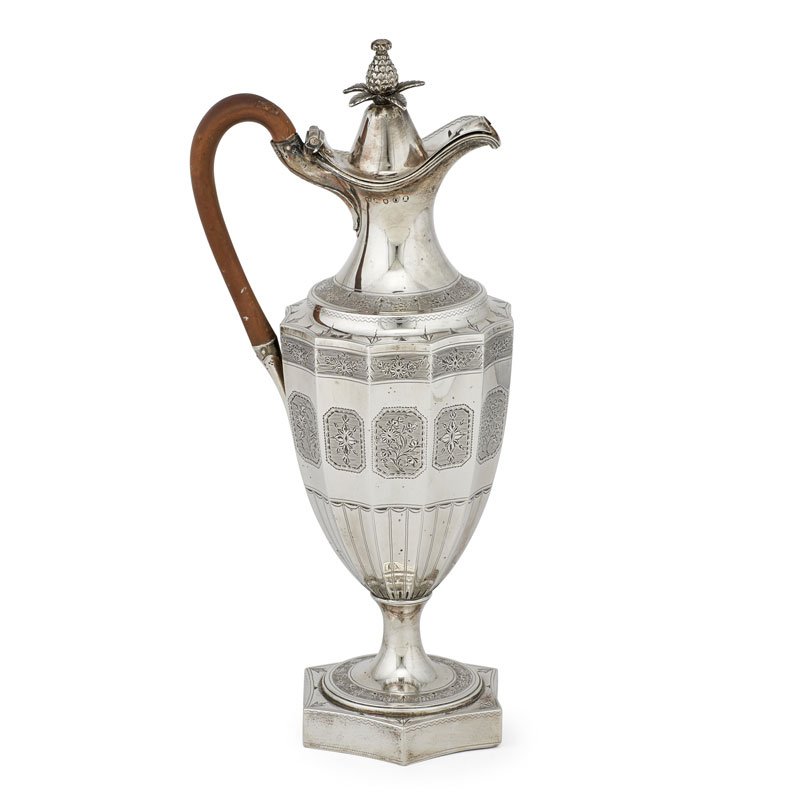 GEORGE III SILVER WINE EWER: Tall urn-form body with hinged lid topped with pineapple finial and wood handle, floral garlands to shoulder and alternating floral panels with armorial center on body, raised on flared circular foot 