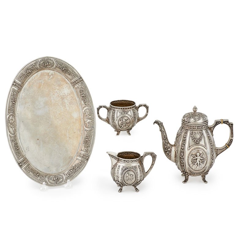 GERMAN .800 SILVER TEA SET: Four: Teapot, creamer, sugar, and platter with repousse floral and cherubic vignettes, Germany, early 20th c.; Marked; Platter: 11 3/4" x 8 1/4"; 37.3 OT