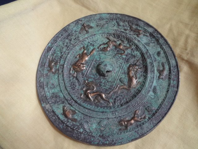 Gilt Bronze Mirror with Chinese Characters: Han Dynasty (206BC-AD220).The mirror was depicted with four gilt animals in the middle and six others on the border. Diameter 8.5 in.