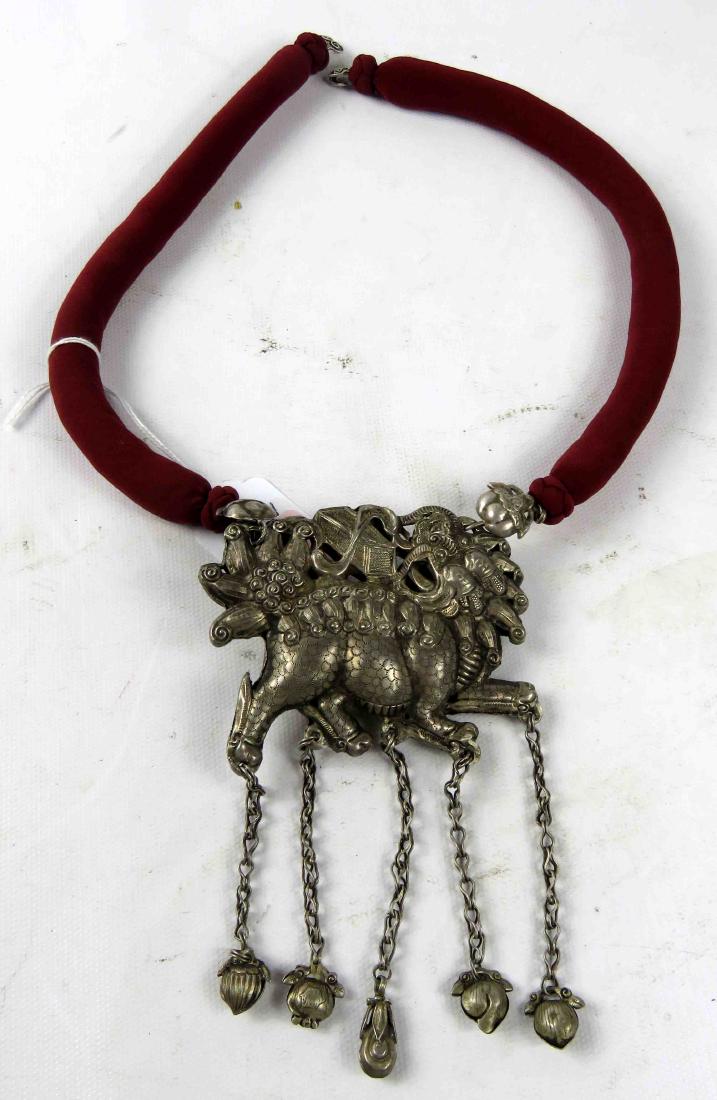 ANTIQUE CHINESE SILVER KYLIN AMULET WITH (5) TASSELS ON: ANTIQUE CHINESE SILVER KYLIN AMULET WITH (5) TASSELS ON CLOTH ROPE CHAIN. AMULET/3 1/2 X 2 3/4"; TASSELS/LENGTH 2 3/4"