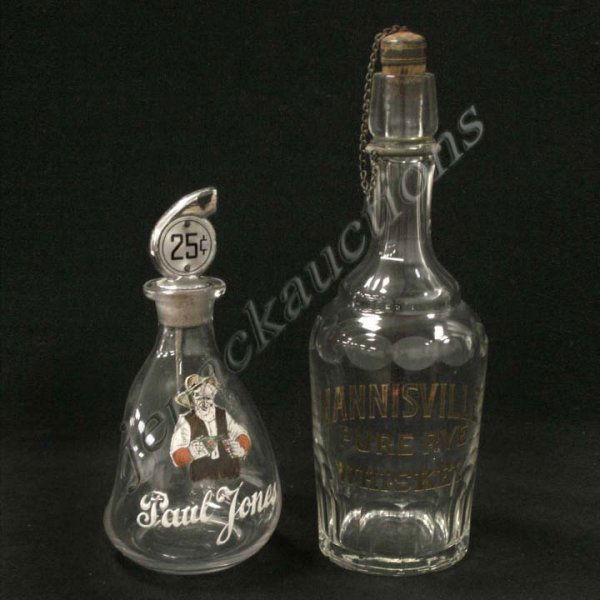 VINTAGE HANNISVILLE AND PAUL JONES WHISKEY BOTTLES: LOT (2) VINTAGE WHISKEY BOTTLES INCLUDING HANNISVILLE PURE RYE WHISKEY, HEIGHT 11 1/2" WITH ORIGINAL STOPPER; PAUL JONES ENAMELED PINCH BOTTLE WITH VENDOR TOP, HEIGHT 8 1/2"
