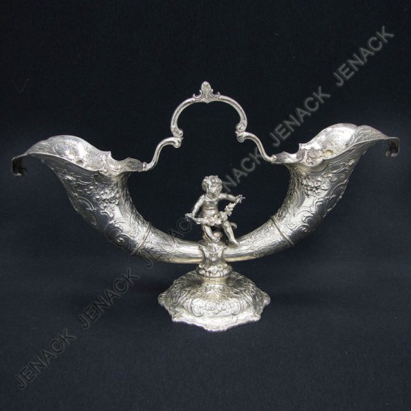 GERMAN SILVER DOUBLE HORN-FORM HANDLED VASE: GERMAN SILVER DOUBLE HORN-FORM HANDLED VASE WITH PUTTI, HALLMARKED B & Z, GERMANY, ST. GEORGE & DRAGON (OTHER ILLEGIBLE MARKS). HEIGHT 9"; LENGTH 14 1/2"; 22.8 OZT