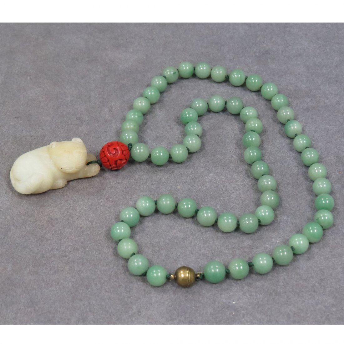 STRAND NECKLACE WITH 9.88-9.95MM CHRYSOPRASE BEADS: STRAND NECKLACE WITH 9.88-9.95MM CHRYSOPRASE BEADS, CARVED CINNABAR BEAD, AND HARDSTONE FOO DOG. NECKLACE/LENGTH 23"; FOO DOG/LENGTH 1 1/2"