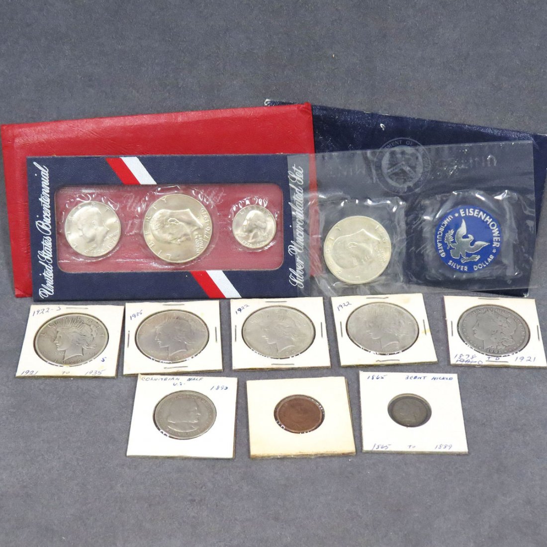 LOT (12) INCLUDING (5) ASSORTED MORGAN DOLLARS: LOT (12) INCLUDING (5) ASSORTED MORGAN AND PEACE SILVER DOLLARS, 1892 COLUMBIAN HALF DOLLAR, 1864 SHIELD 2-CENT, 1865 3-CENT NICKEL, 1976 BICENTENNIAL SET (UNC), 1971 EISENHOWER SILVER DOLLAR (UNC)