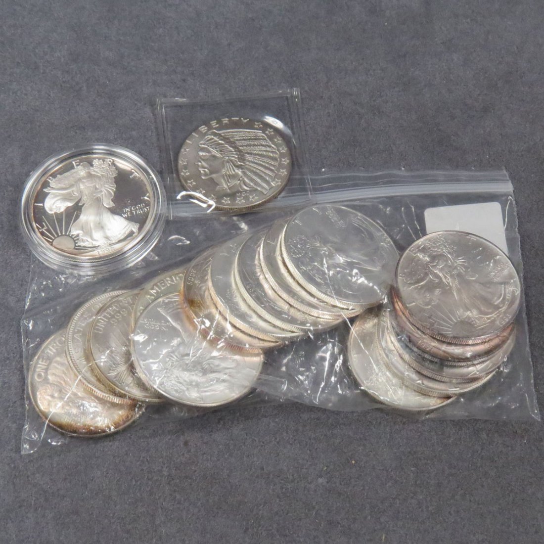 LOT (17) INCLUDING (13) AMERICAN EAGLE DOLLARS: LOT (17) INCLUDING (13) ASSORTED AMERICAN EAGLE SILVER DOLLAR COINS AND (4) ASSORTED SILVER ROUNDS. 17 OZT