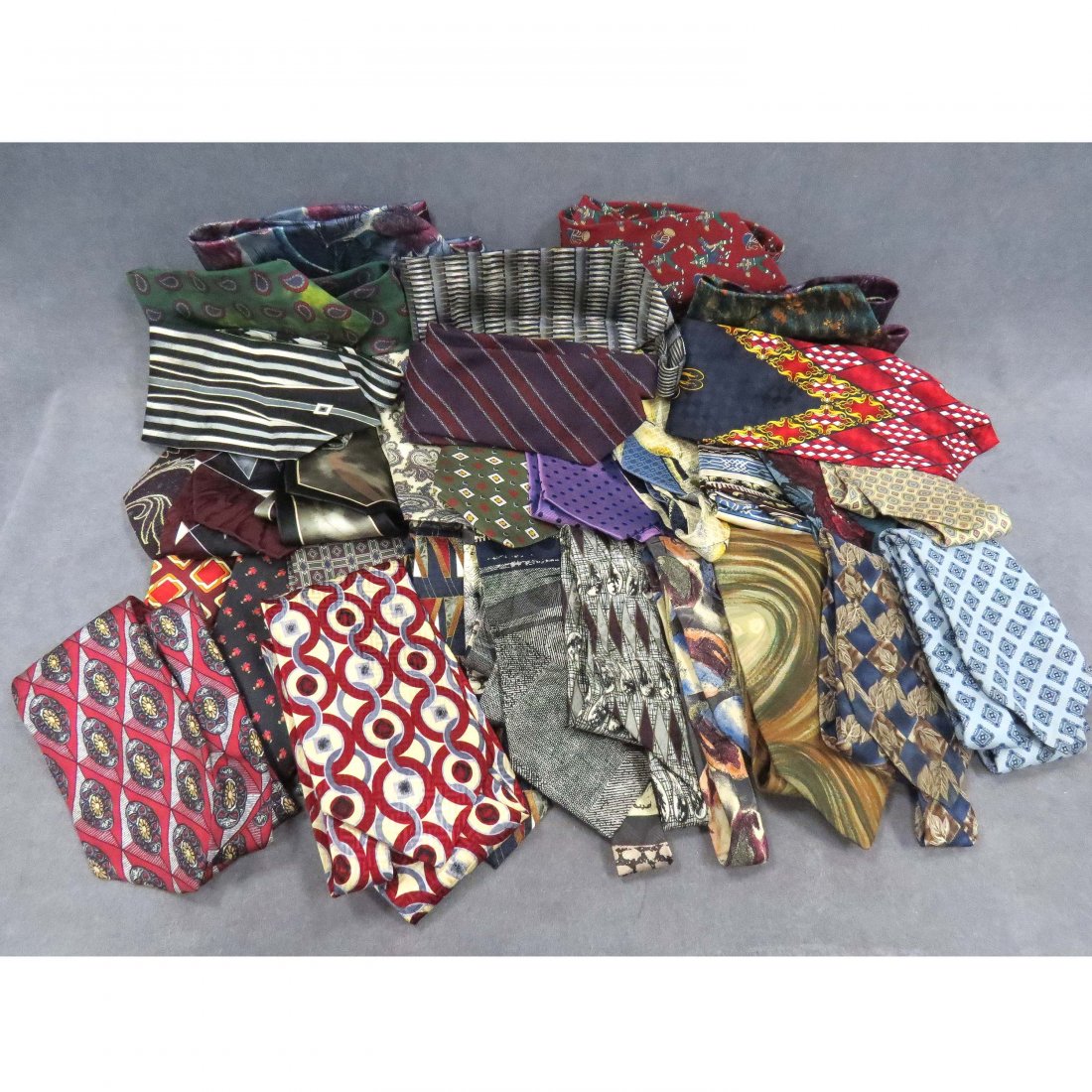 LOT ASSORTED DESIGNER SILK NECK TIES: LOT ASSORTED DESIGNER SILK NECK TIES, APPROXIMATELY 30 INCLUDING ENRICO VENTARI, W.V. BROWN, J. FERRAR, HENRI CHRISTIAN, GEORGE MOCHADO, ENRICO GUCCINI, PIERRE CARDIN, DANIEL DE FASSON, PERRY ELLE, VE