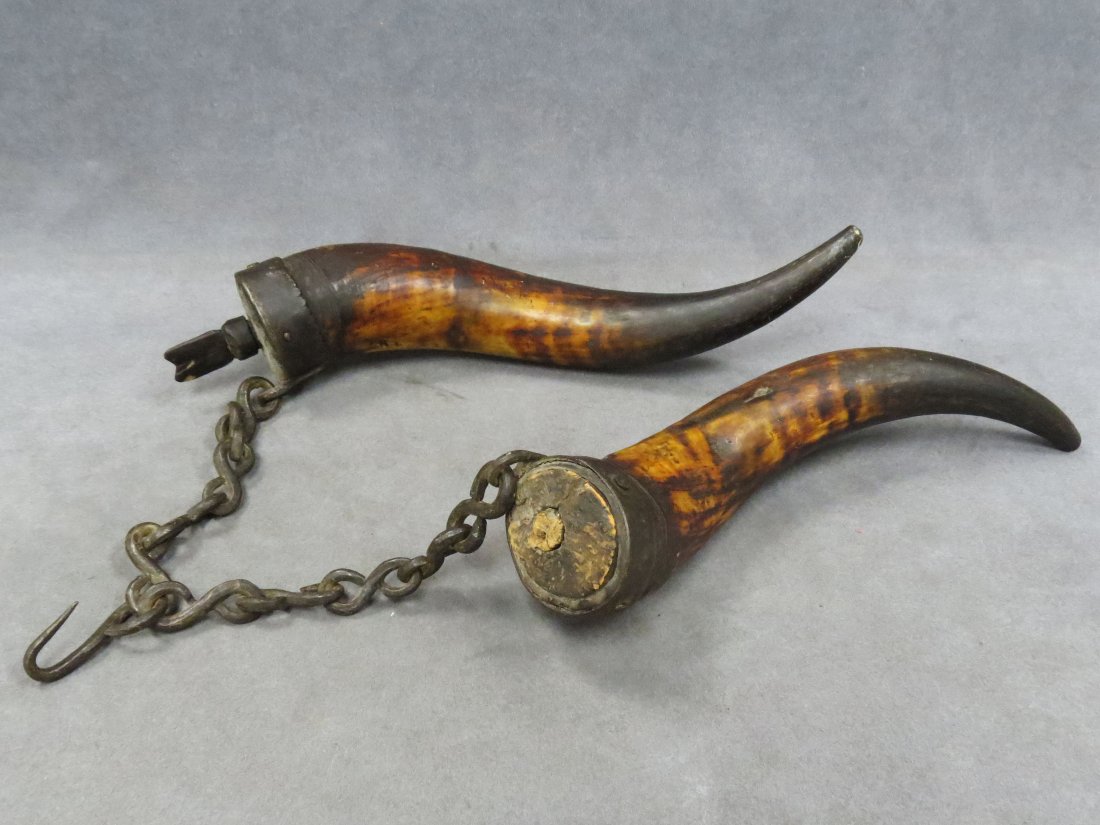PAIR POWDER HORNS WITH WROUGHT IRON MOUNTS: PAIR POWDER HORNS WITH WROUGHT IRON MOUNTS AND CHAIN. HEIGHT 12 1/2"