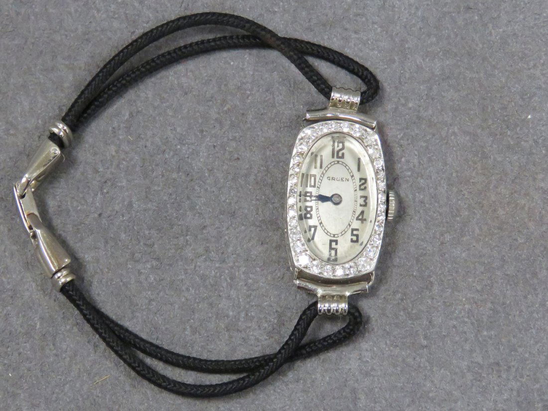 VINTAGE GRUEN PLATINUM AND DIAMOND WRISTWATCH: VINTAGE GRUEN PLATINUM AND DIAMOND 17-JEWEL LADY'S WRISTWATCH, BLACK CORD BAND WITH 18K WHITE GOLD FITTINGS (MONOGRAMMED CASE)