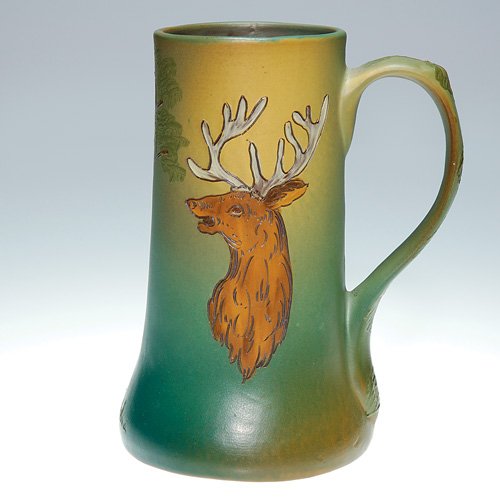Weller Dickens Ware 6 1/2" mug with deer: Weller Second Line Dickensware 6 1/2 inch mug decorated with the bust of a deer with a tree to the side. Impressed on base with Dickensware Weller logo, X 327 and bearing an incised letter M. No crazi