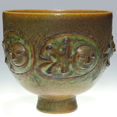 Edwin Scheier 'Face" vase, 6 1/2" X 7: Edwin Scheier 6 1/2 inch by 7 inch vase with repeating design of five oval panels, each featuring a primitive appearing face and covered with a good green and brown glaze. Incised 'Scheier" on bottom