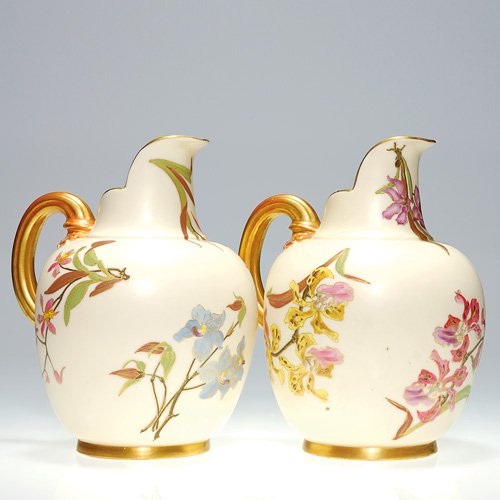 Royal Worcester two 7 5/8" pitchers, orchids: Roual Worcester lot of two 7 5/8 inch pitchers, each with colorful floral decoration and showcasing orchids, with gilding at rim, handle and base. Each is marked with the Royal Worcester crown logo, s