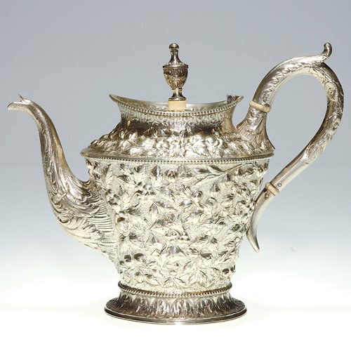 S Kirk & Son silver teapot, repousse, 6 3/4: Attractive S. Kirk & Son silver individual tea pot with repousse pattern of leafing branches and flowers. Height 6 3/4 inches. The pot has a hinged cover and ivory connectors on the finial and handle.