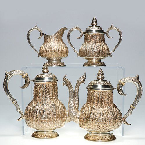 Thainakon, Thailand 4pc silver coffee & tea set: Decorative sterling silver coffee and tea set featuring an elaborate 'Siam" design. The 9 inch coffee pot and 8 inch tea pot spouts are formed as a neck of a dragon, the handles have ivory connectors,