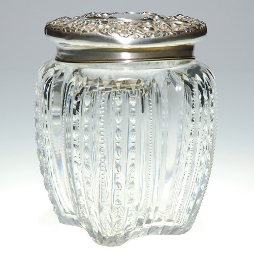 Cut Glass humidor, sterling cover, 6: Humidor with a sterling repousse cover. The melon body has vertical bars cut with prism patterns. The ornate floral cover is impressed 'Sterling" and numbered 356. Pressure applied to the cover has de