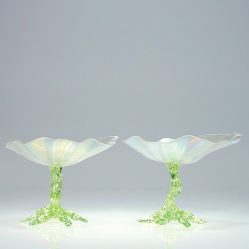 2 English lily compotes, stems w/root base, 5": Pair English compotes, attributed to Thomas Webb having verre de soie lily pod trays on green stems steadied by a root base. The 6 1/2 inch trays are multi ribbed, the surface reflecting rainbow iride