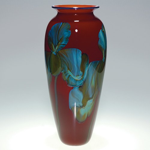 Richard Satava glass vase, irises, 1994, 12 3/8: Richard Satava ruby red vase onto which he placed four iris blossoms with large frilly petals created in nice contrasting colors of olive green and robin egg blue. Height 12 3/8 inches. Engraved 'R. S
