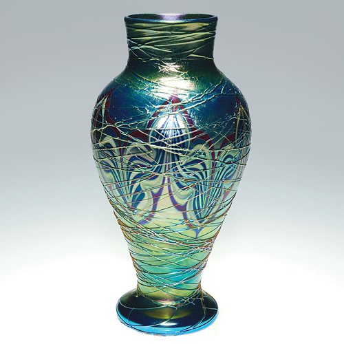Orient & Flume vase, feather,threaded, 8 5/8: Early Orient & Flume vase a nice aurene blue with colorful and decorative pulled design about the girth and applied threading that cris-cross the entire form. Height 8 5/8 inches. Engraved with the co