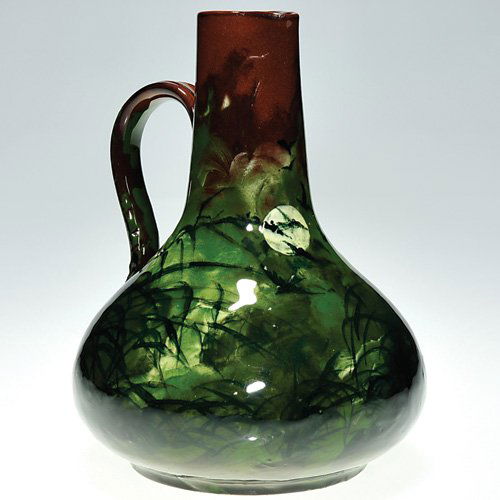 Rookwood 6 1/8" claret jug, moon/birds, AH, 1882: Early Rookwood claret jug, formed of red clay, decorated with a night time scene of birds flying across a full moon with Oriental grasses also present, finished in a Limoges glaze, the work of Albert