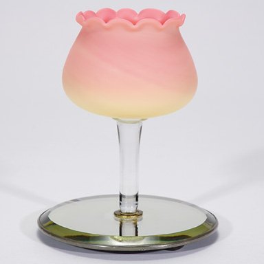 Webb Burmese epergne on mirror, 7 1/2": Graceful Burmese epergne created by Thomas Webb & Sons, the floral form, in acid finish, is lofted upon a crystal stem fixed onto a mirrored base. Height 7 1/8 inches. The beveled edged mirror has a f