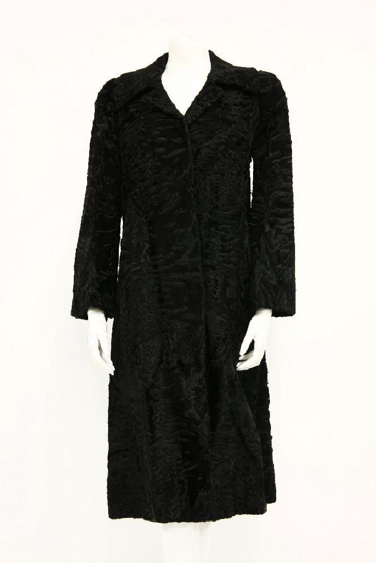 A black astrakhan or seal fur mid-length coat: A black astrakhan or seal fur mid-length coat,with lapel collar and black silk lining,size 10-12