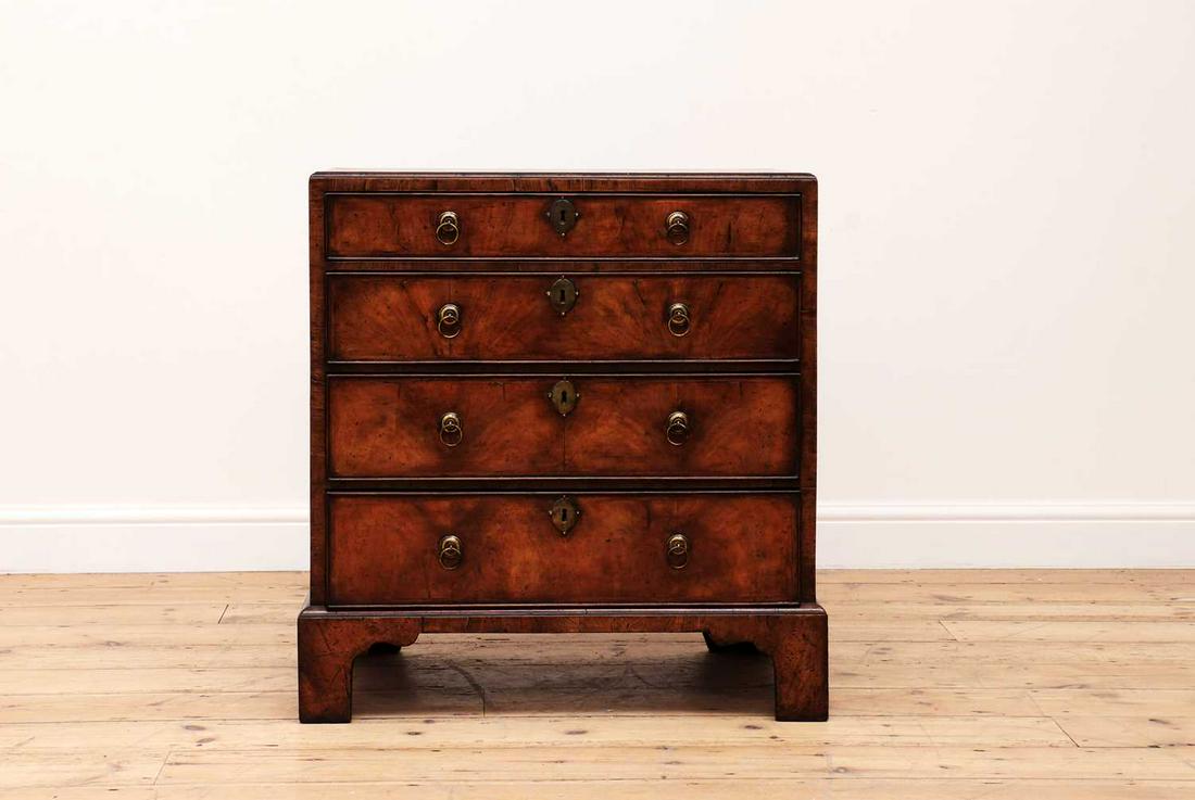 A small George I-style walnut chest of drawers,: A small George I-style walnut chest of drawers, A small George I-style walnut chest of drawers, 18th century and later, the crossbanded and quarter-veneered caddy top over four graduated long drawers,
