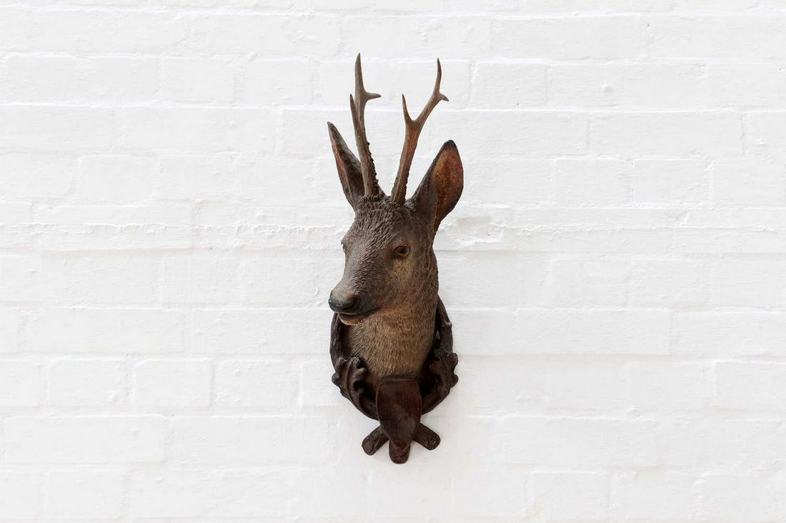 A Black Forest terracotta roebuck trophy head,: A Black Forest terracotta roebuck trophy head, A Black Forest terracotta roebuck trophy head, early 20th century, fitted with real antlers, within an oak leaf and rusticated integral frame, 58cm high 