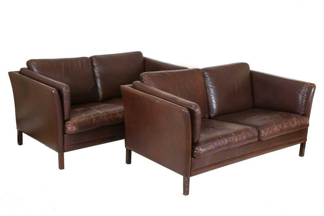A pair of Danish leather two-seater settees,: A pair of Danish leather two-seater settees, each with a dark brown leather seat and back, raised on stained supports, 150cm wide 80cm deep 75cm high, seat 41cm high (2) Condition Report: Both with cr