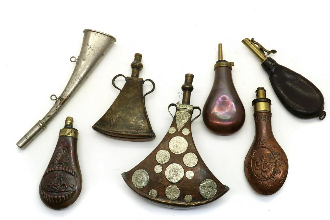 A collection of powder and shot flasks: A collection of powder and shot flasks A collection of powder and shot flasks, 20th century, comprising a North African example, three embossed copper flasks, a nickel plated horn, (7) Condition Repor