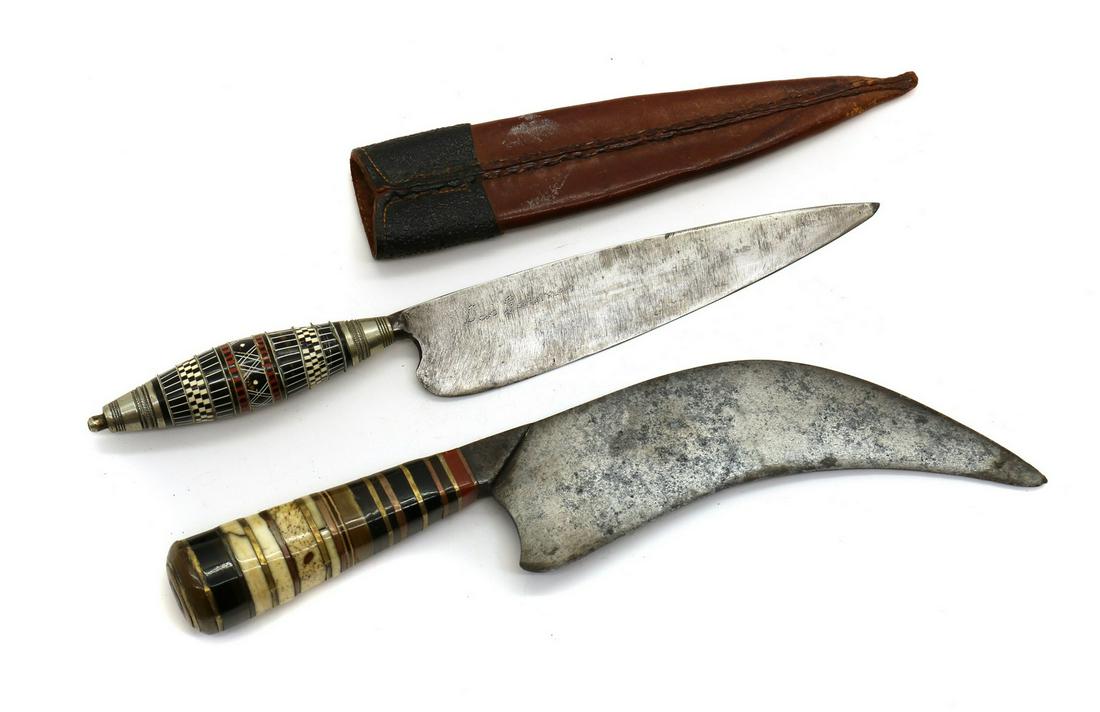A Spanish or South American knife: A Spanish or South American knife A Spanish or South American knife, 20th century, 6.25in blade with tapering layered hilt and leather sheath, 28cm overall, and a South American knife, with 7in incurv