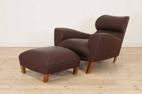 An 'Aston' armchair and ottoman,: An 'Aston' armchair and ottoman, An 'Aston' armchair and ottoman, designed by David Linley for Linley, with swept armrests following through to a tapering backrest, raised on oak supports curved inwar