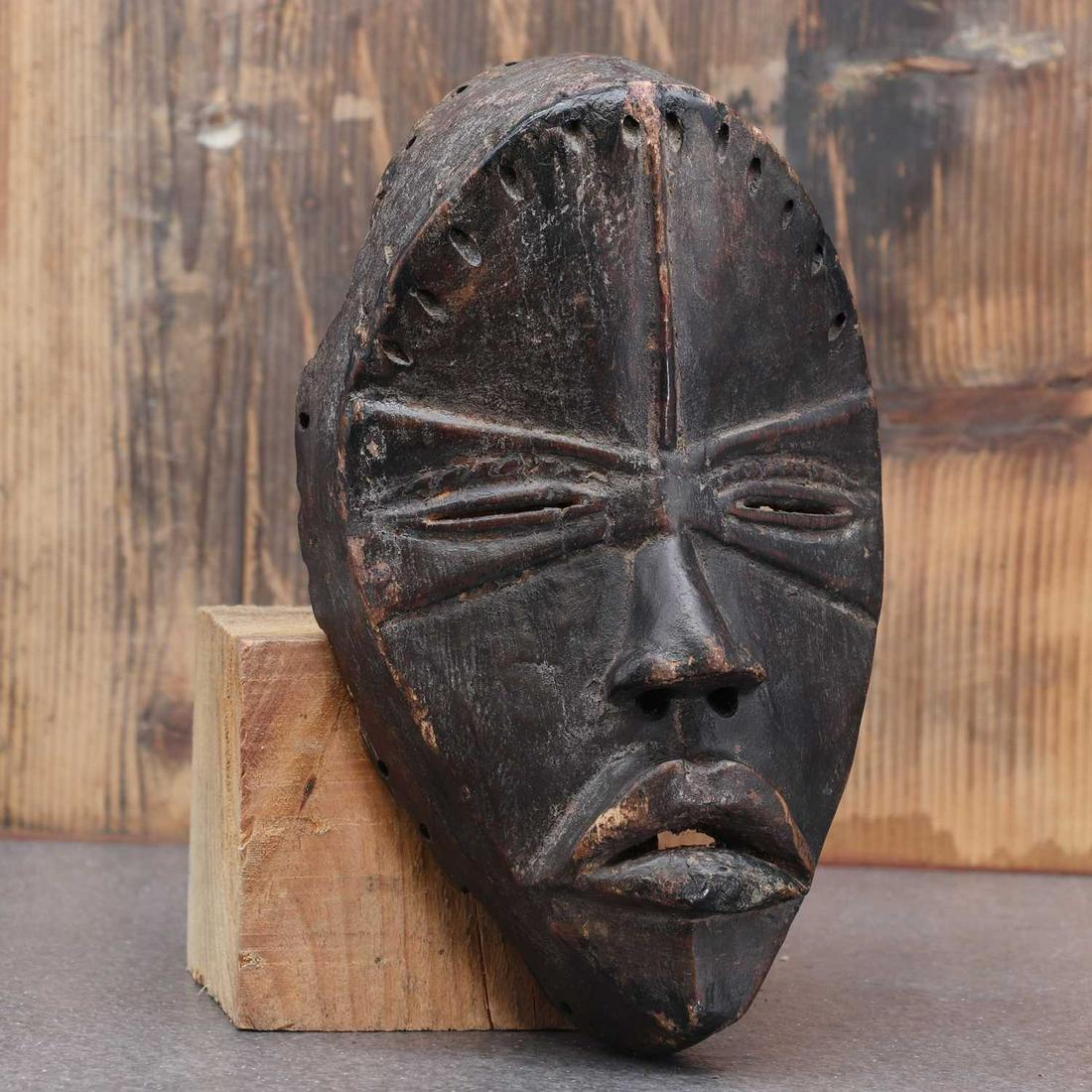 Dan society: a carved and patinated Dan mask, (1 of 3)