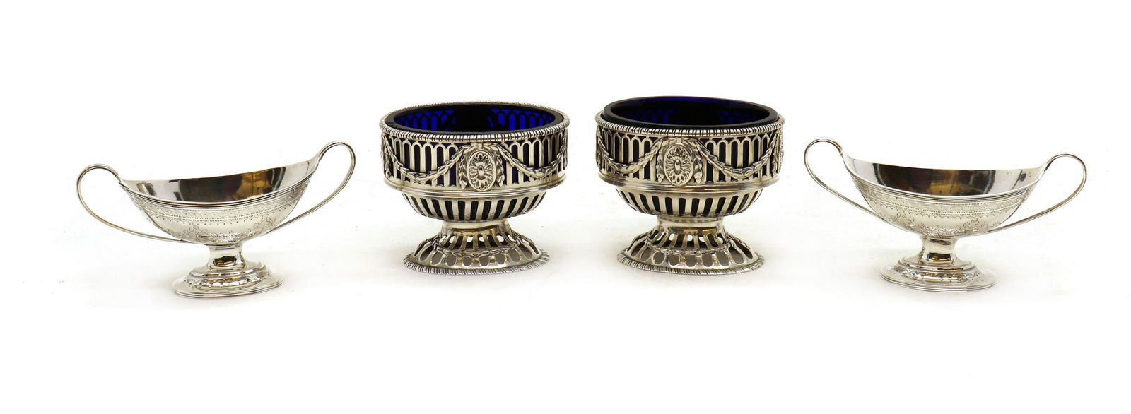 A pair of George III silver pedestal salts: A pair of George III silver pedestal salts A pair of George III silver pedestal salts, with pierced decoration, 7cm high together with a pair of Victorian twin handled salts, by Charles Stuart Harris,
